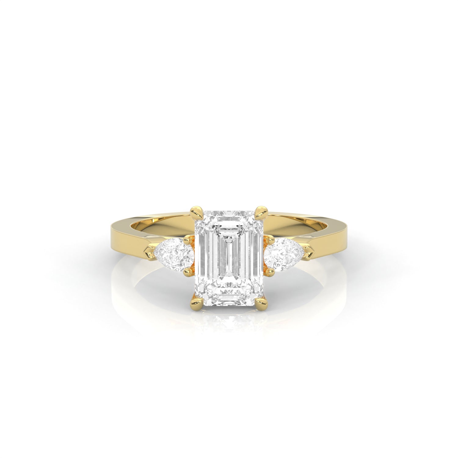 yellow gold ring with emerald-cut diamond and pear diamonds on the sides against a white background