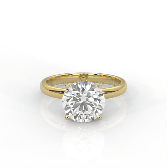 Yellow gold solitaire ring with round diamond on a white background