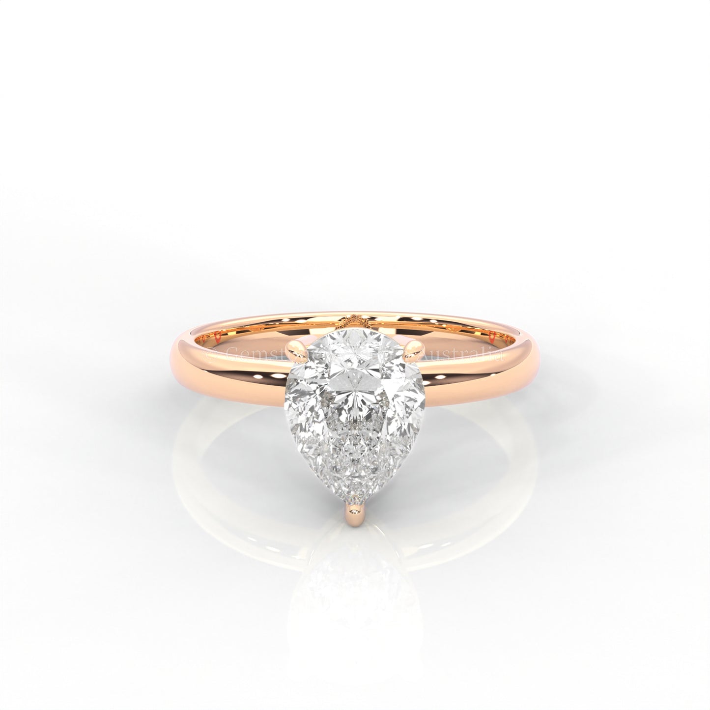 rose gold solitaire ring with pear-cut diamond in a white background
