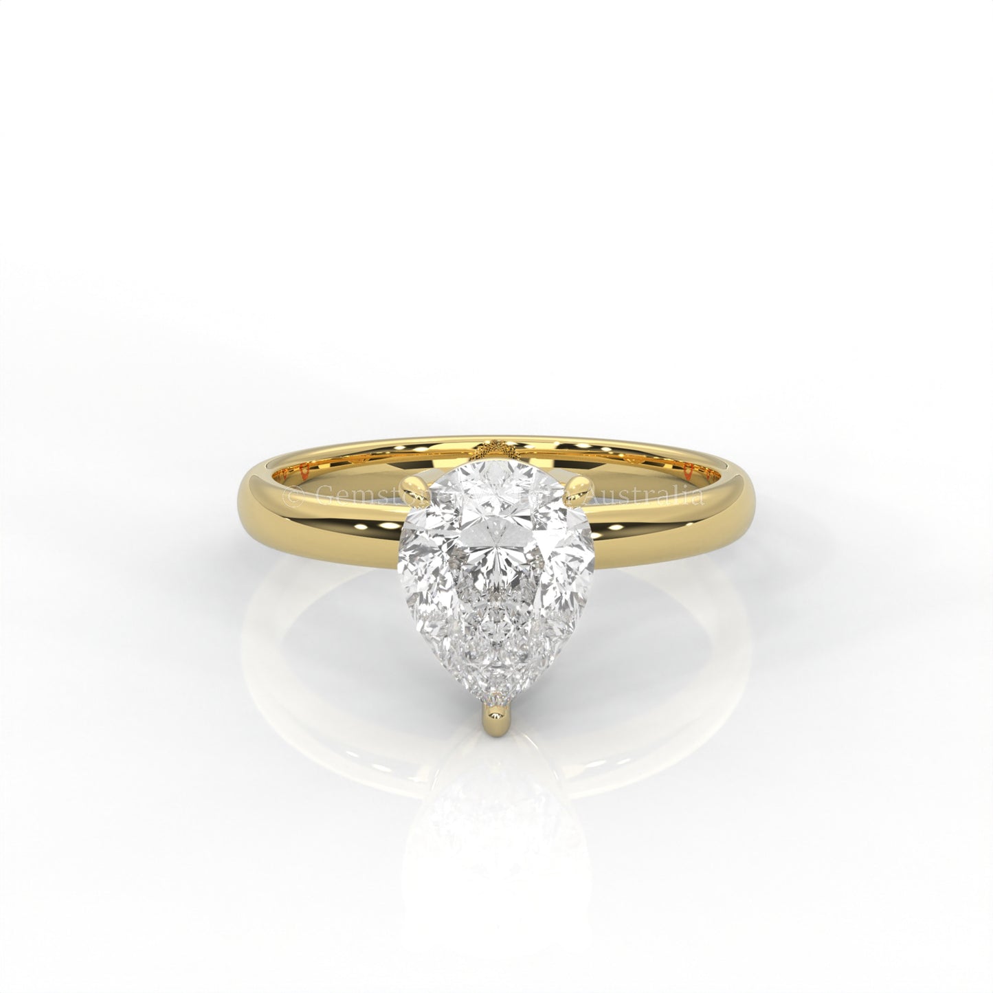 yellow gold solitaire ring with pear-cut diamond in a white background
