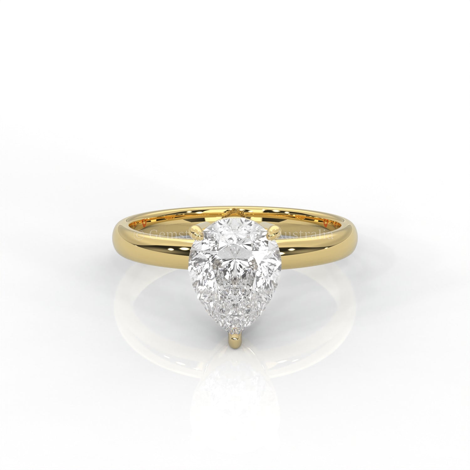 yellow gold solitaire ring with pear-cut diamond in a white background
