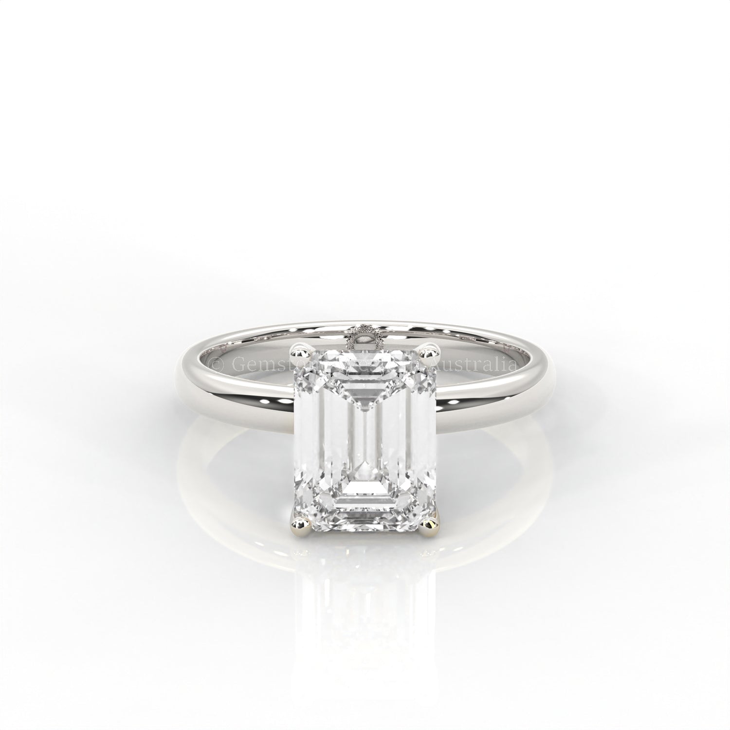 white gold solitaire ring with emerald-cut diamond in a white background