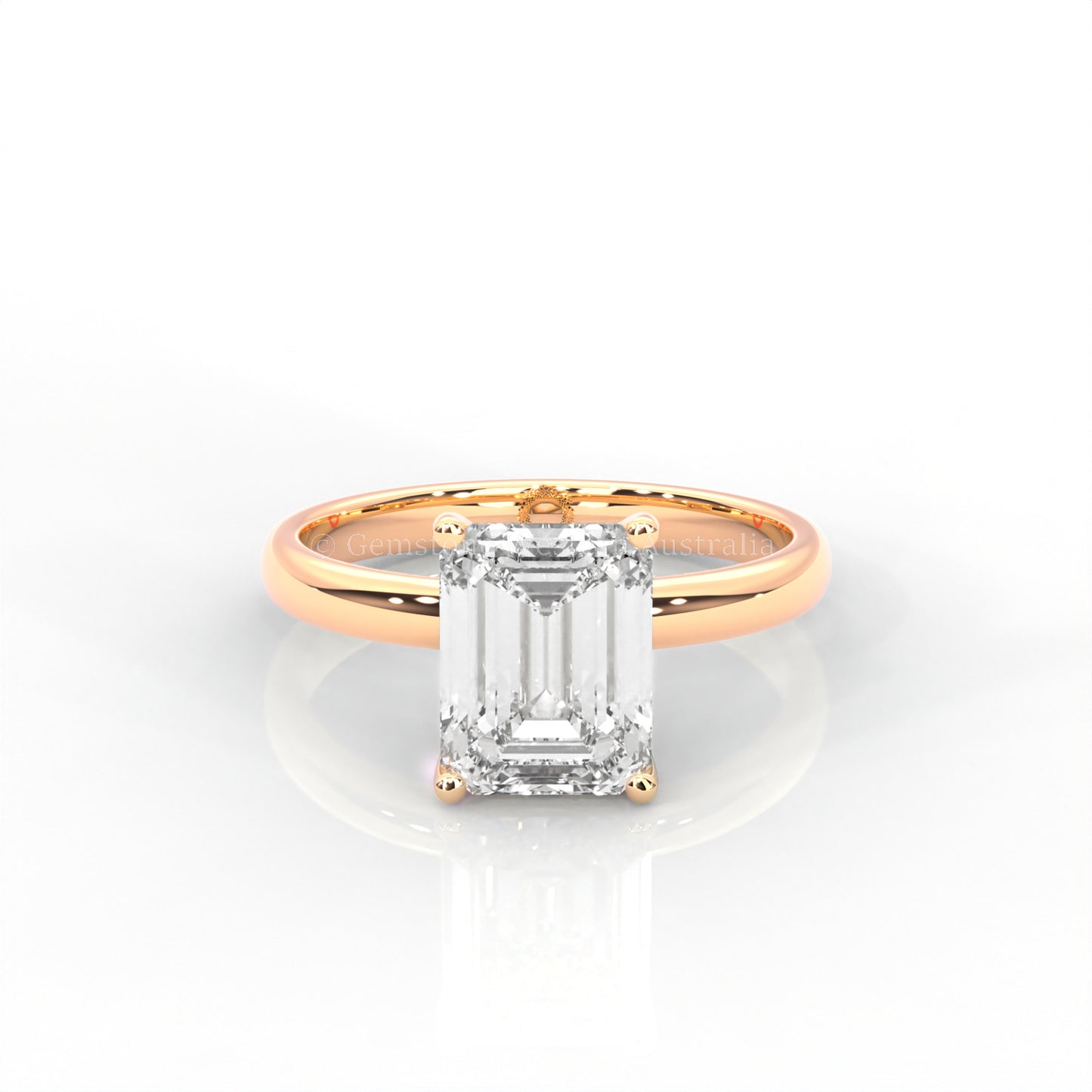 rose gold solitaire ring with emerald-cut diamond in a white background