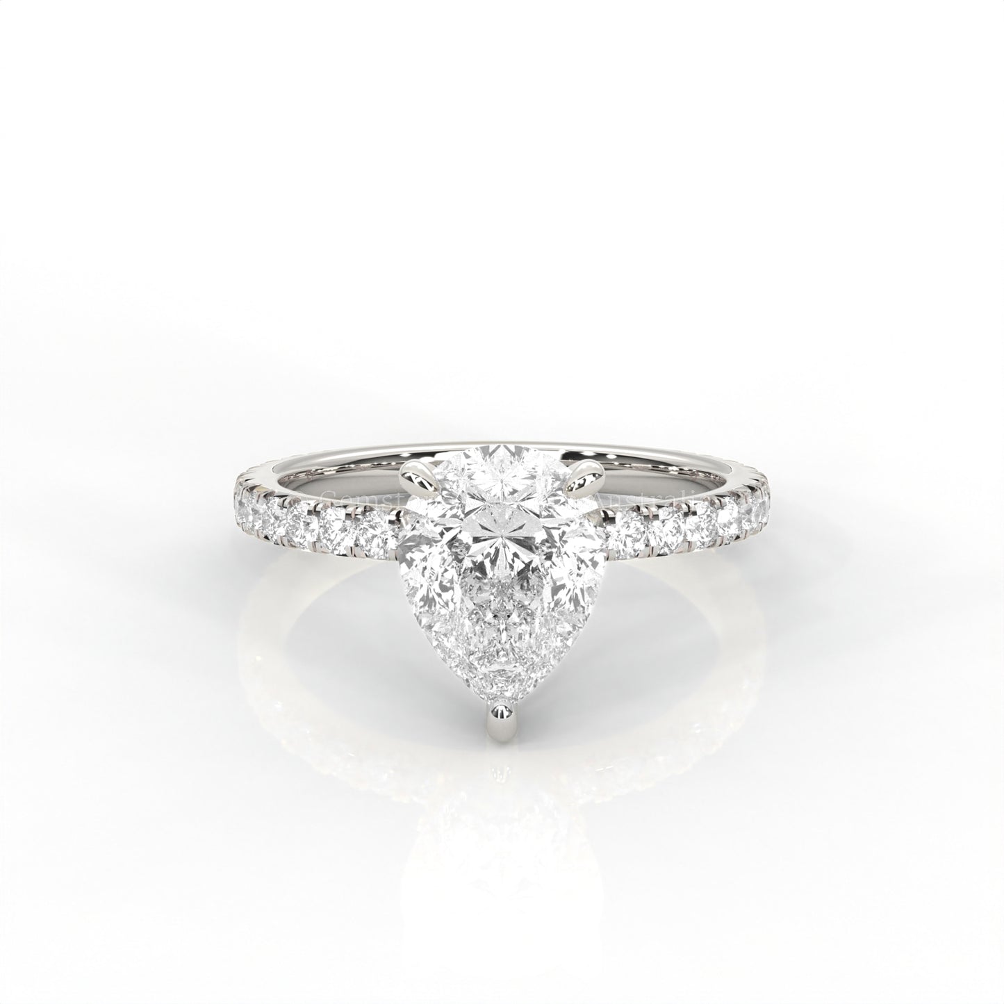 White gold ring with a pear-cut diamond and smaller diamonds on the band against a white background