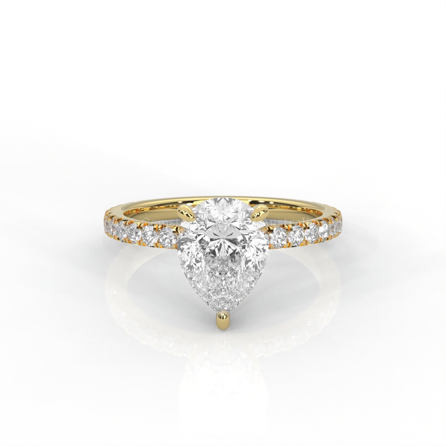 Yellow gold ring with a pear-cut diamond and smaller diamonds on the band against a white background