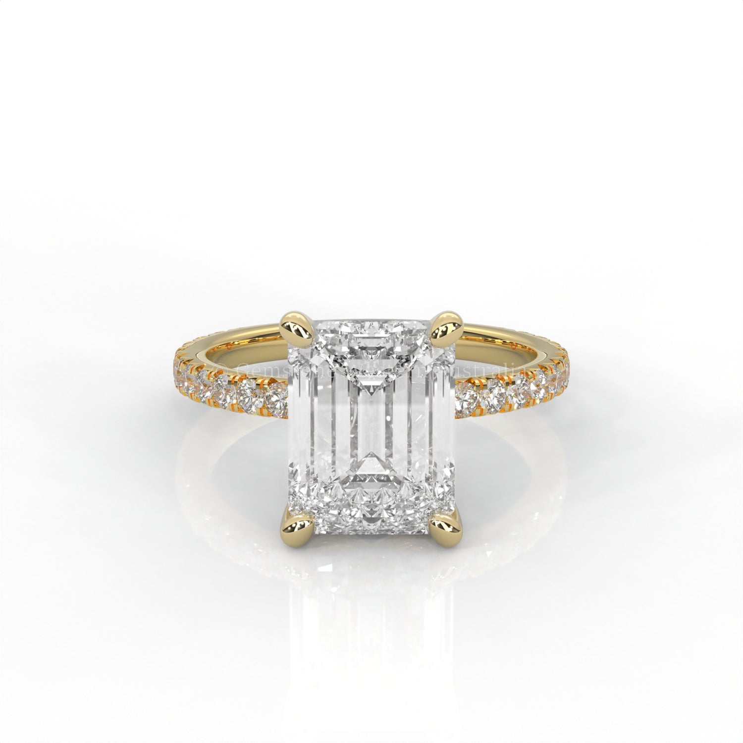 Yellow gold ring with an emerald-cut diamond and smaller diamonds on the band against a white background