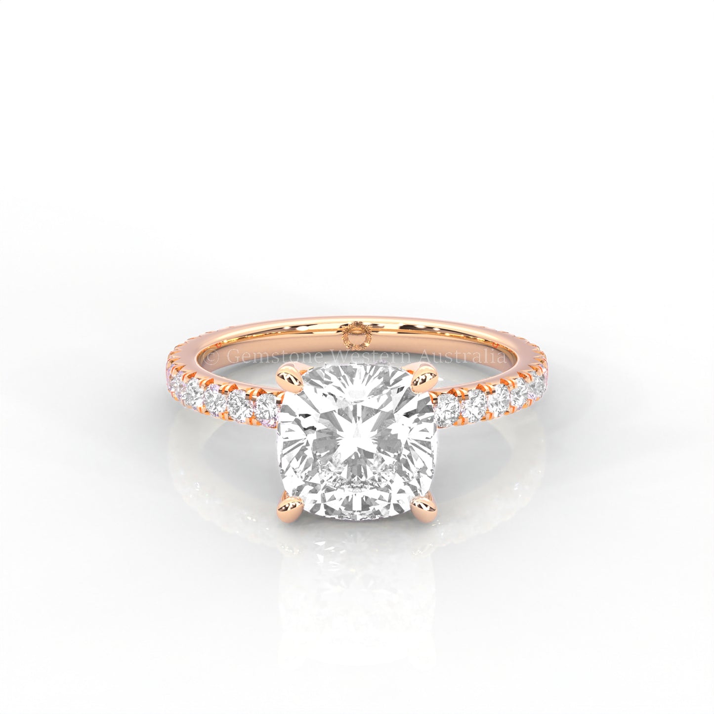 rose gold ring with a cushion cut diamond and smaller diamonds on the band against a white background