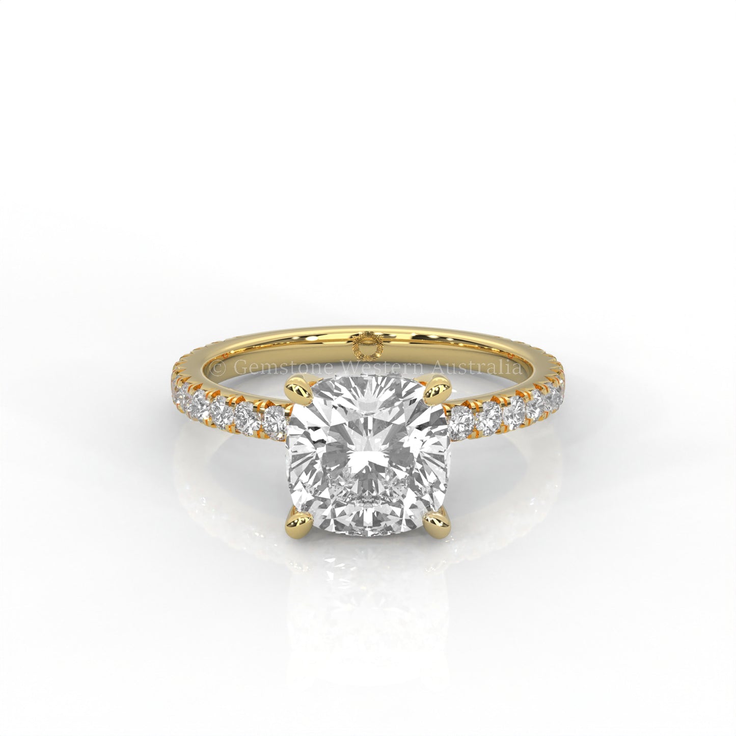 yellow gold ring with a cushion cut diamond and smaller diamonds on the band against a white background