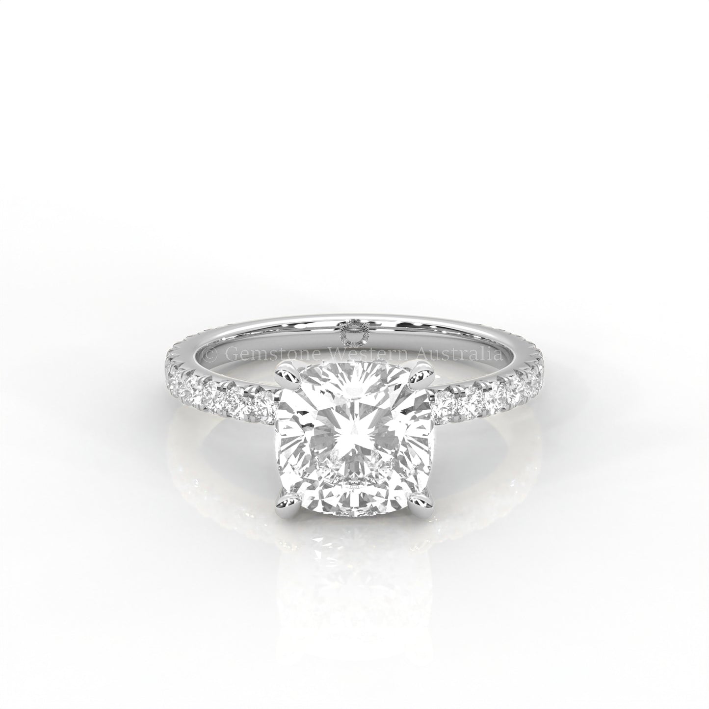 white gold ring with a cushion cut diamond and smaller diamonds on the band against a white background