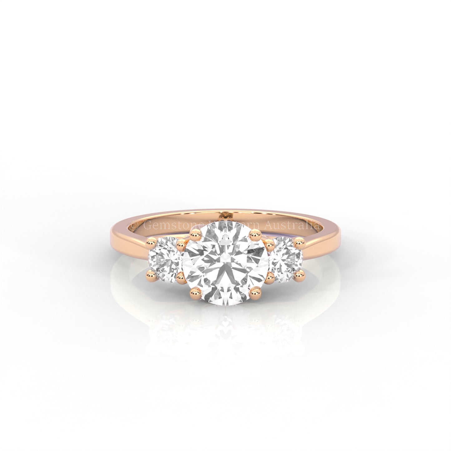 rose gold three stone ring with round side diamonds and round centre stone on white background