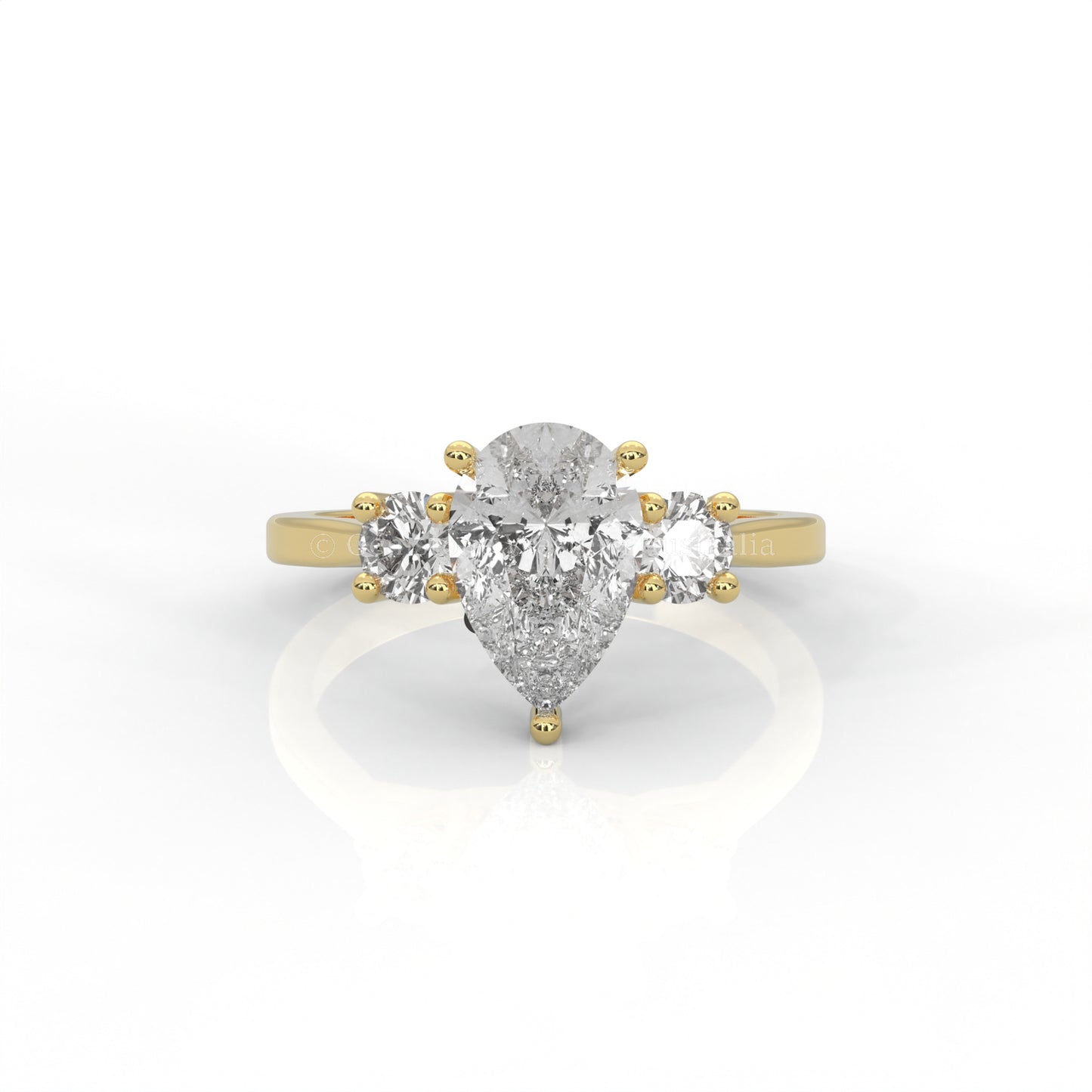 Three stone yellow gold ring with pear-cut centre diamond in white background