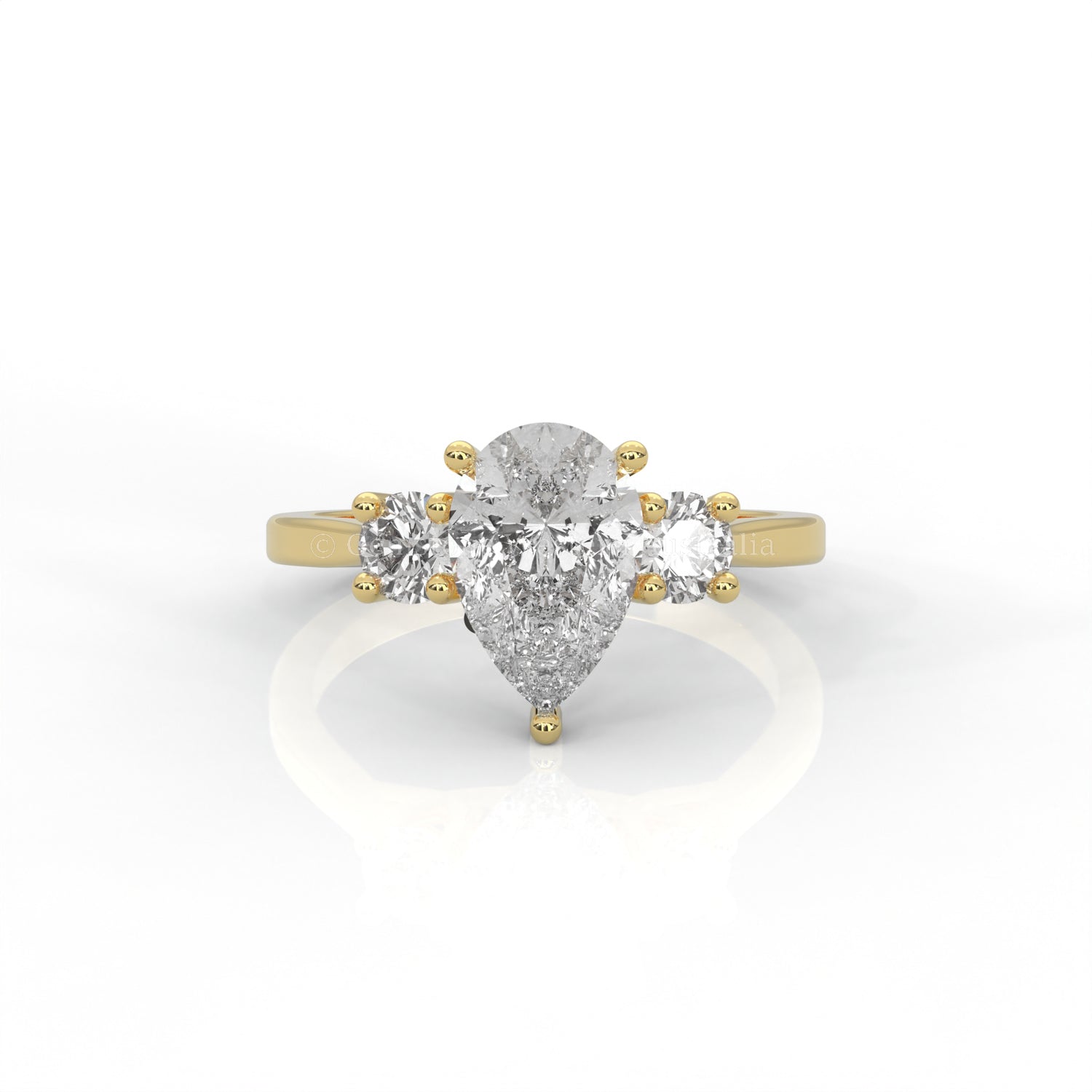 Three stone yellow gold ring with pear-cut centre diamond in white background