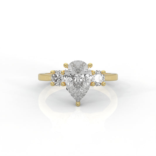 Three stone yellow gold ring with pear-cut centre diamond in white background