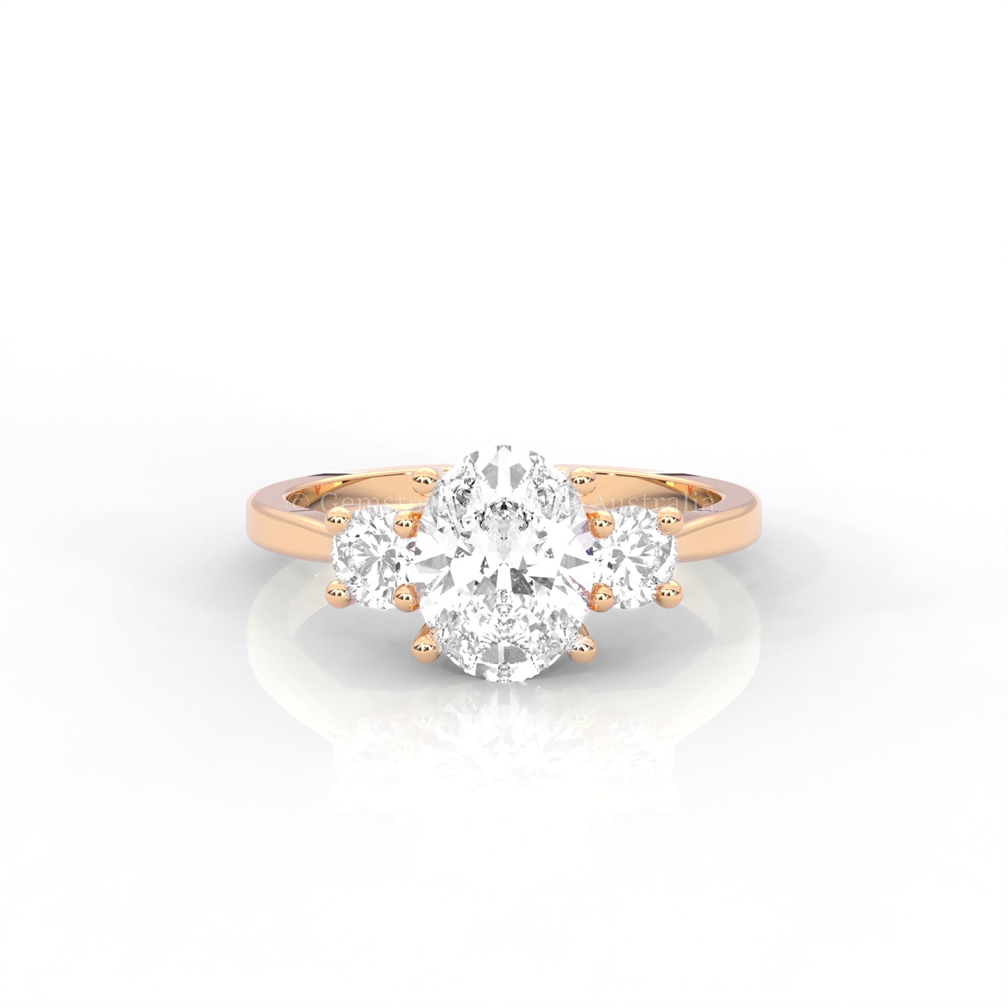 rose gold three stone ring with round side diamonds and oval centre stone on white background