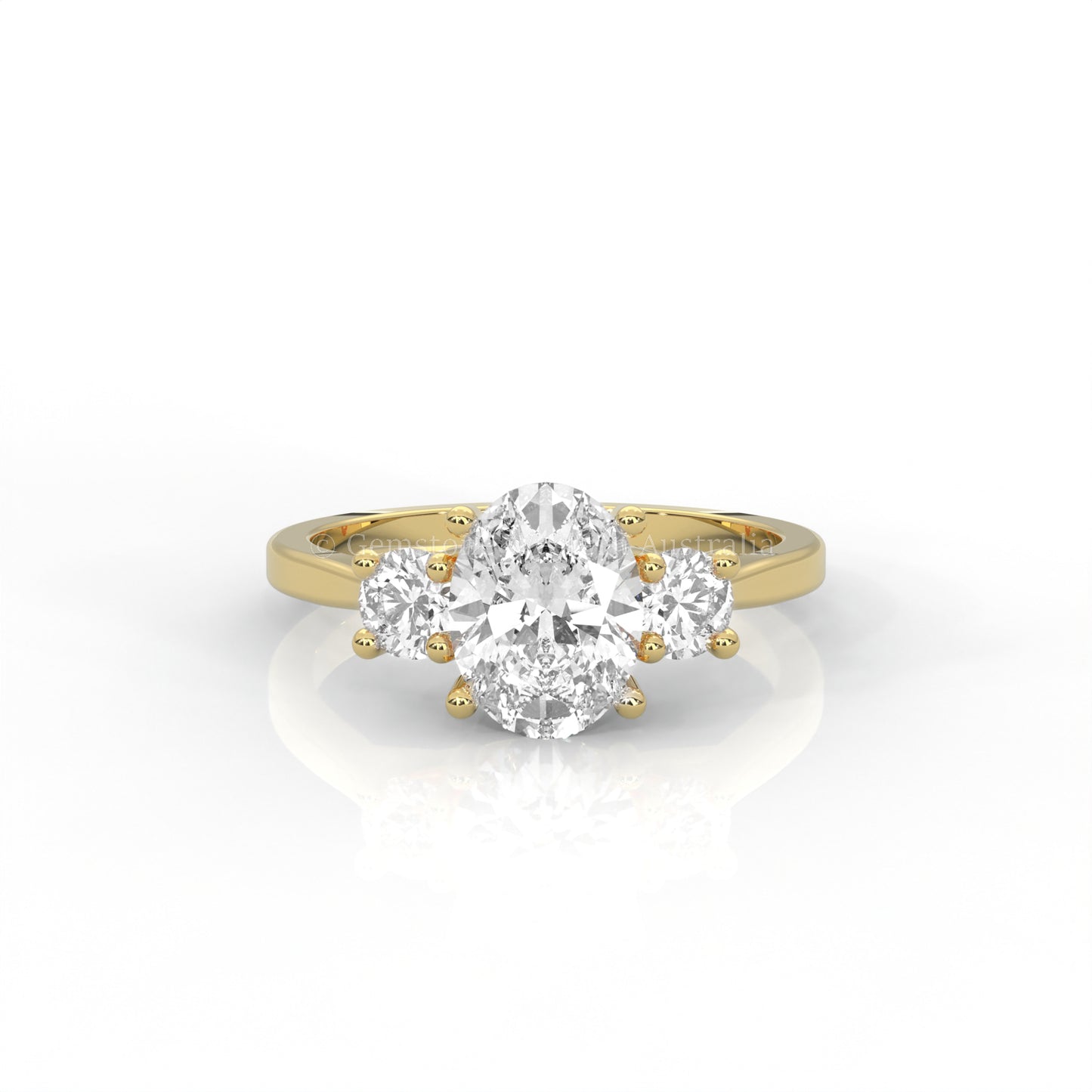 yellow gold three stone ring with round side diamonds and oval centre stone on white background
