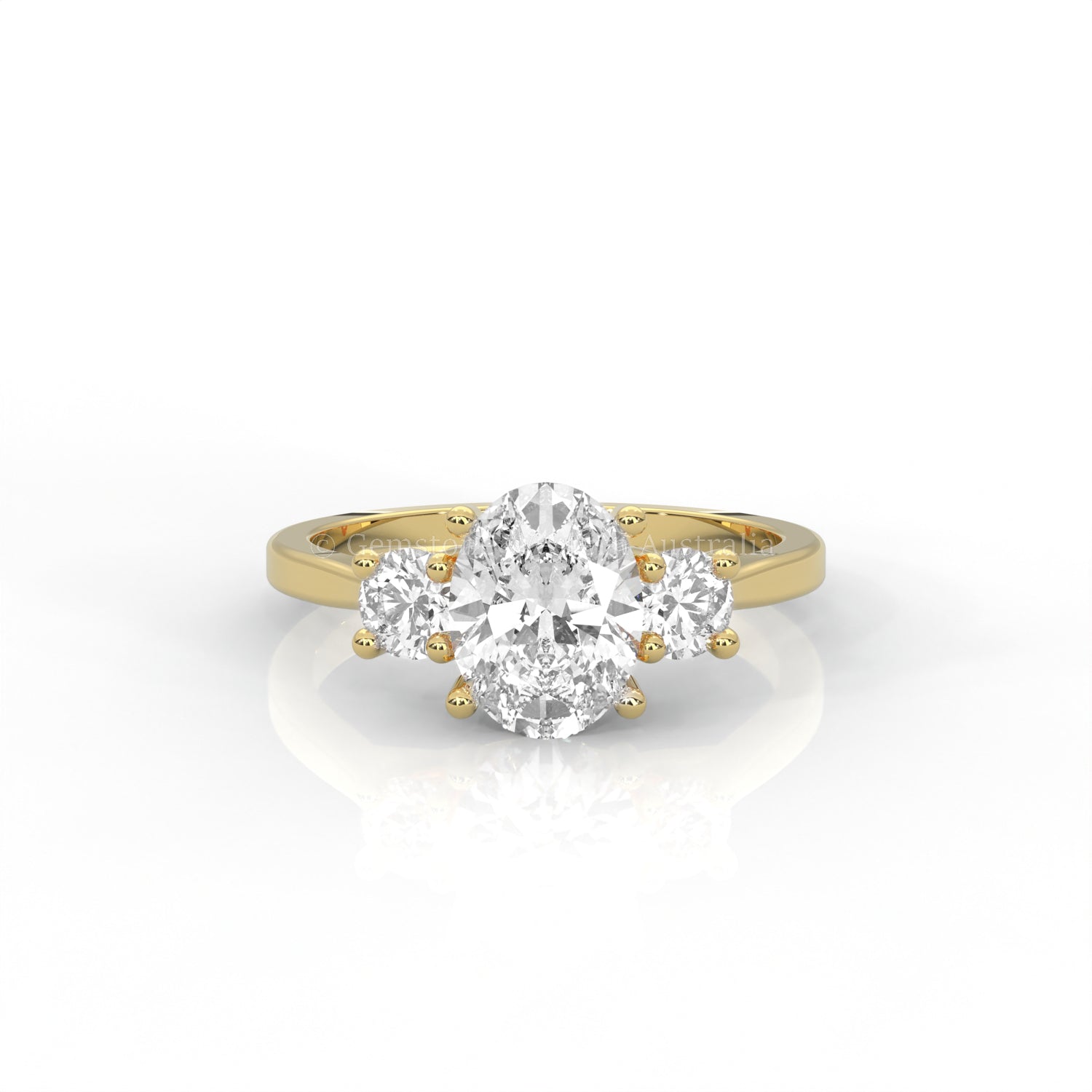 yellow gold three stone ring with round side diamonds and oval centre stone on white background