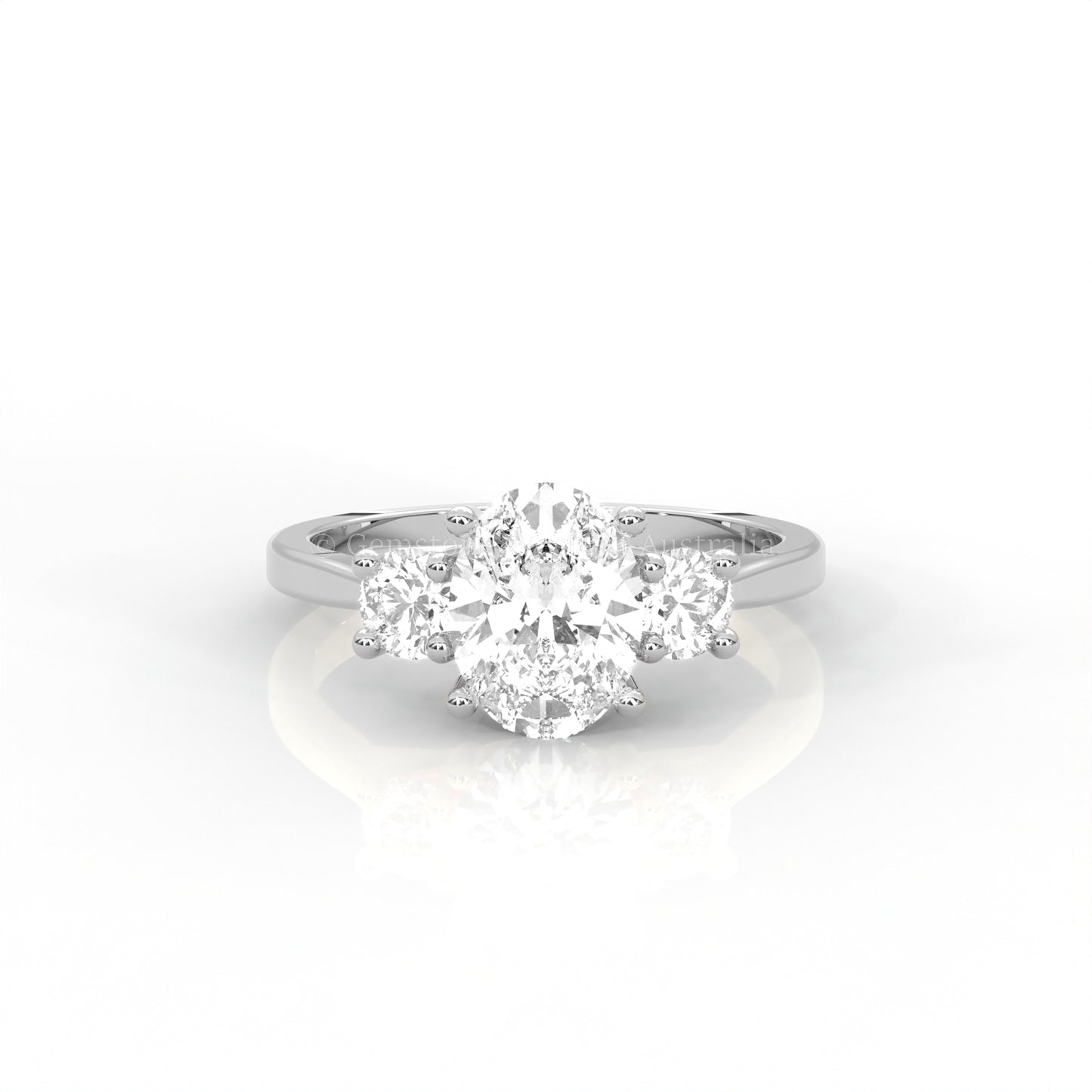 white gold three stone ring with round side diamonds and oval centre stone on white background