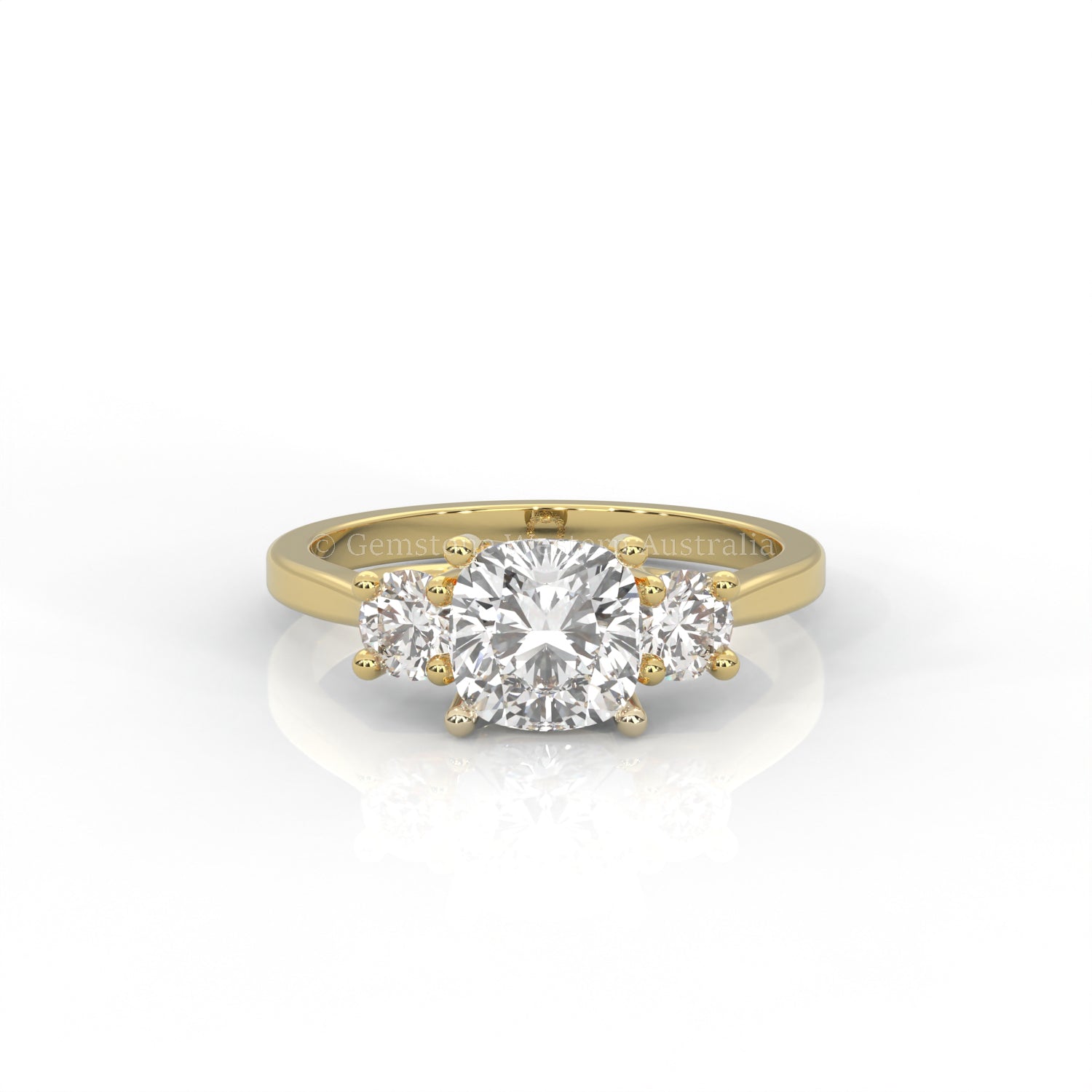 yellow gold three stone ring with round side diamonds and cushion centre stone on white background