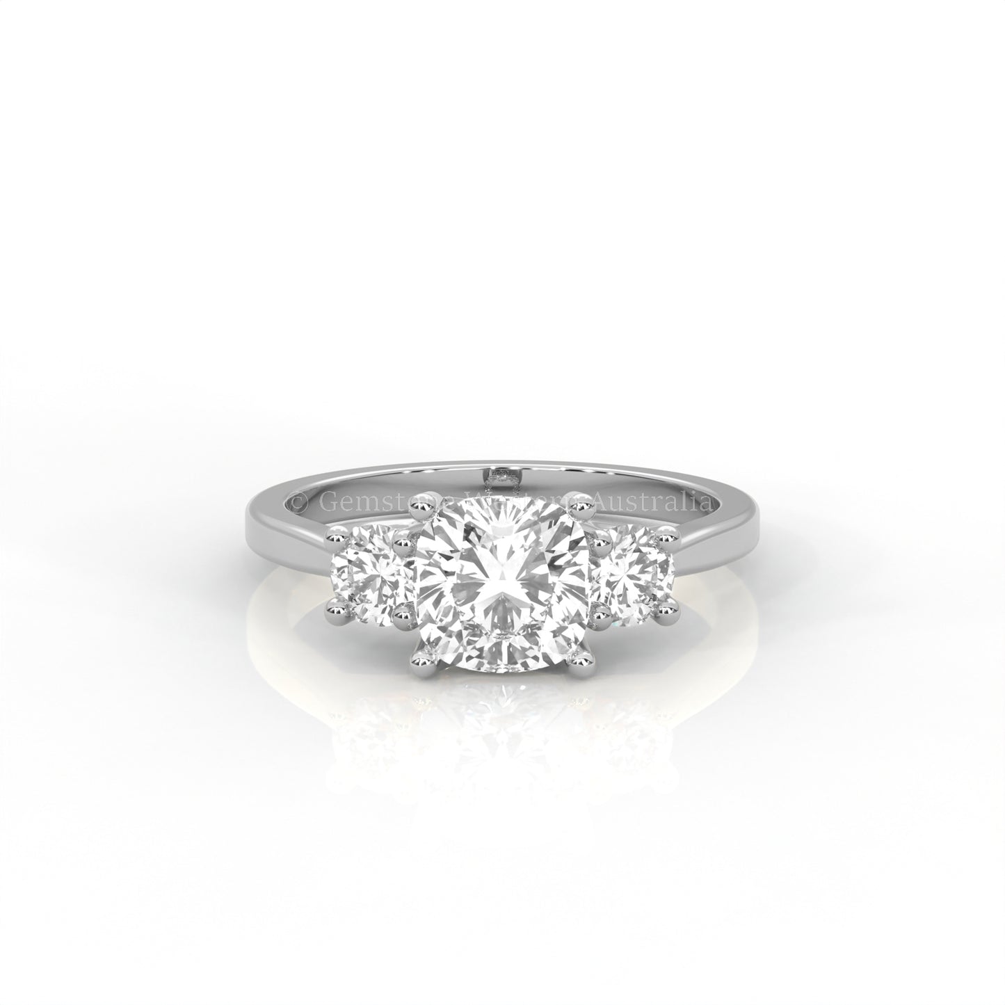 white gold three stone ring with round side diamonds and cushion centre stone on white background