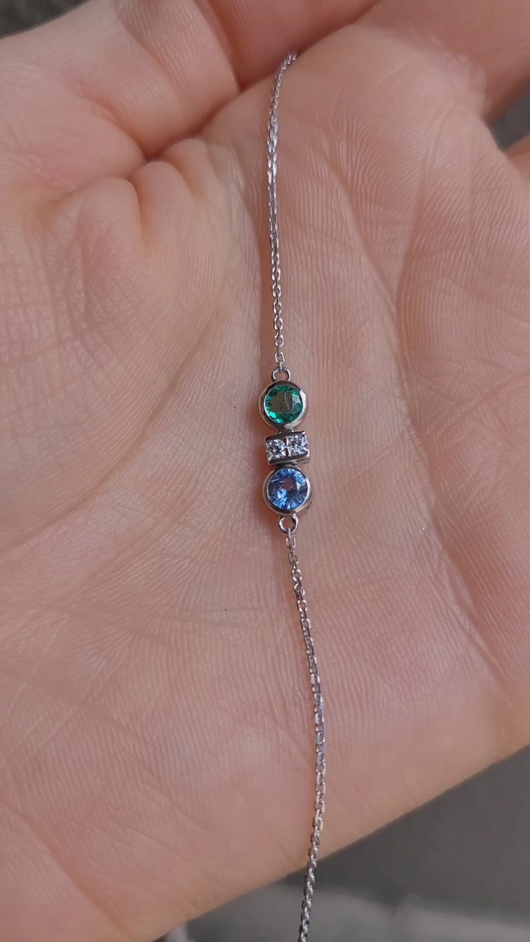 video of Colombian Emerald, Diamond and Blue Sapphire Bracelet in Platinum 950 held in a hand