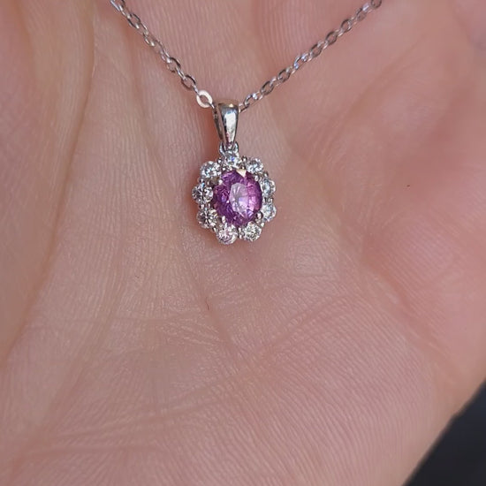 video of platinum pendant with pink sapphire held on hand 