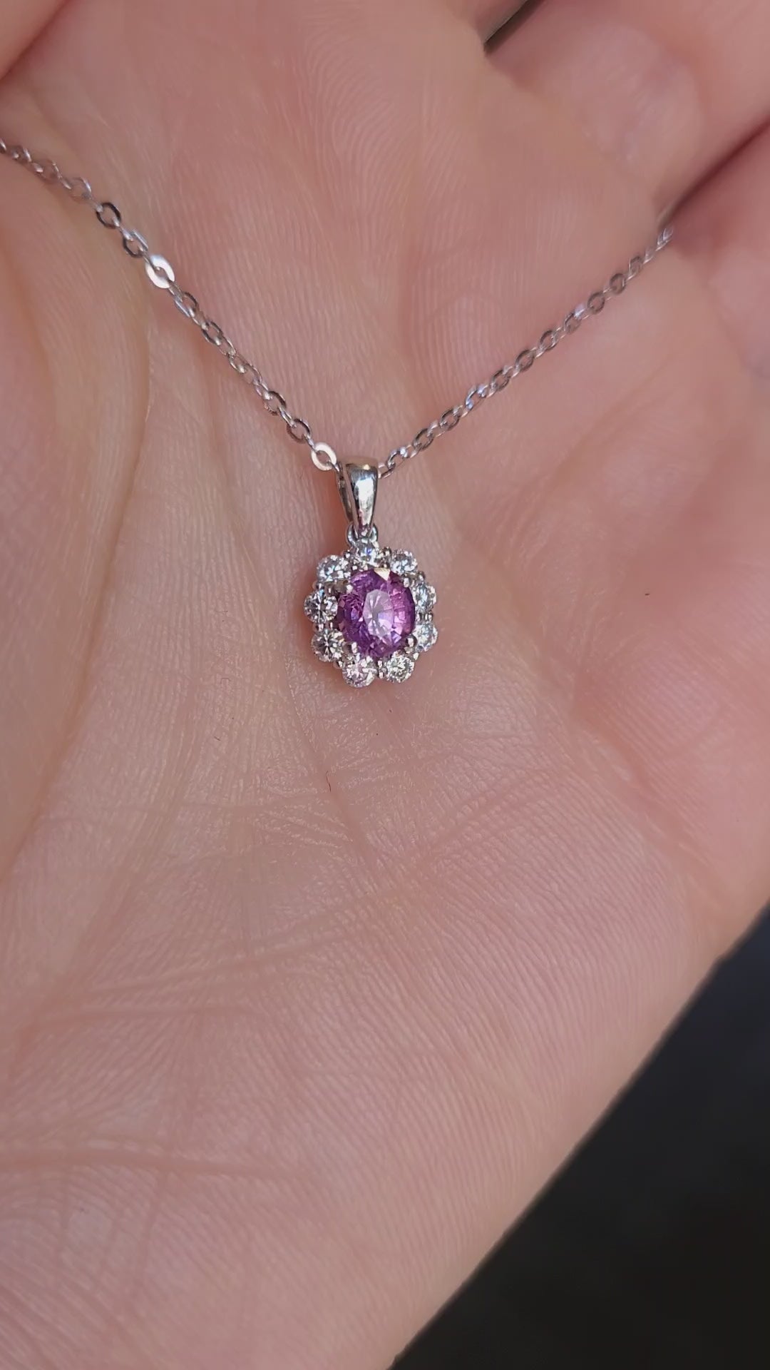 video of platinum pendant with pink sapphire held on hand 
