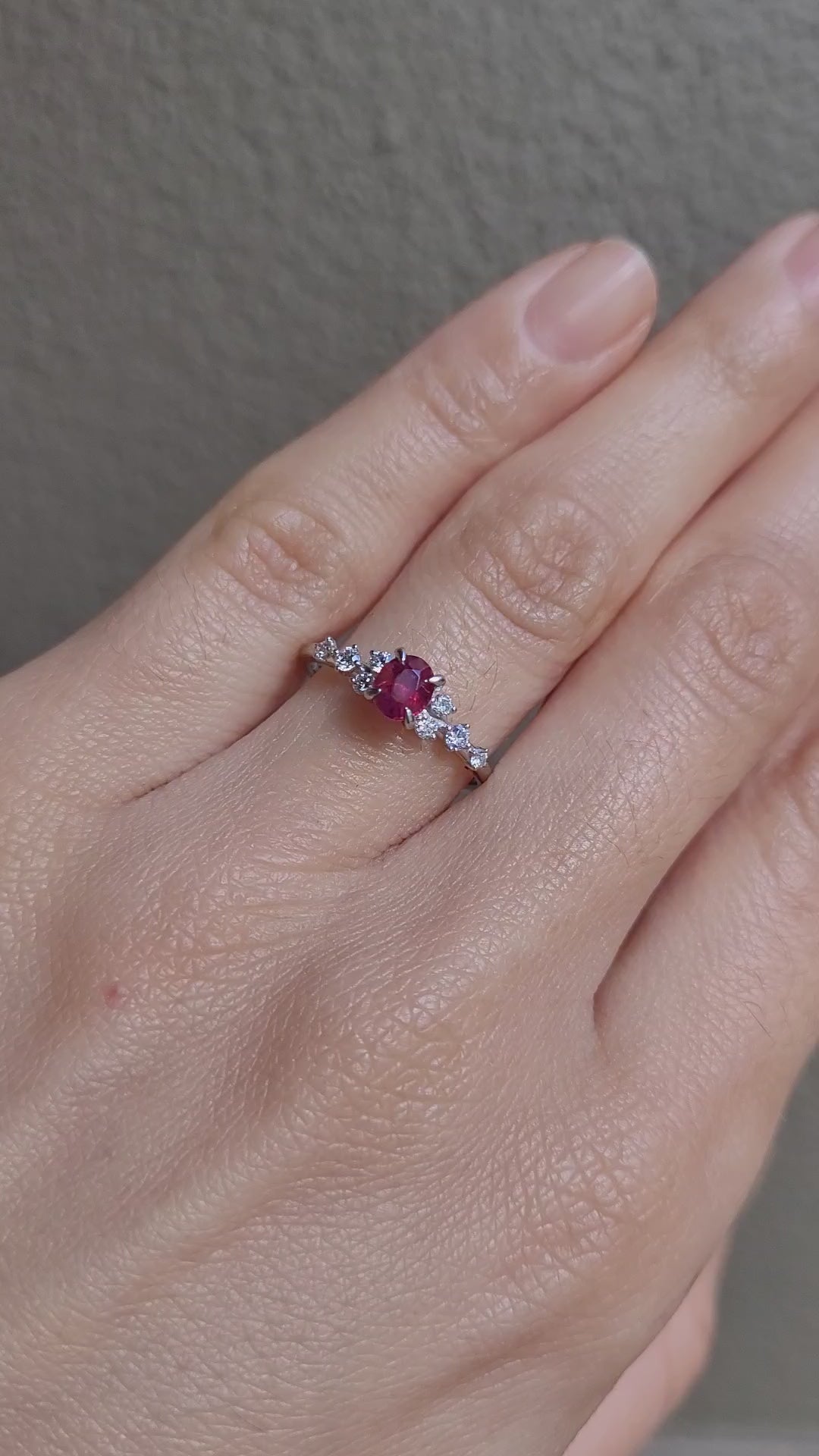 video on of hand wearing a natural ruby and diamond ring in platinum 950 in neutral background