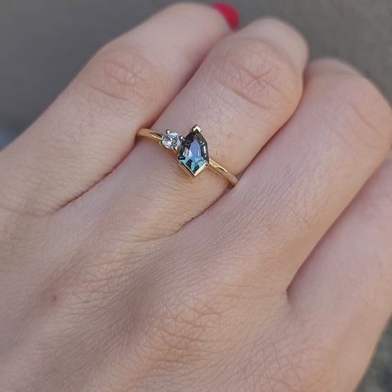 video of toi et moi teal sapphire gold ring in gray background