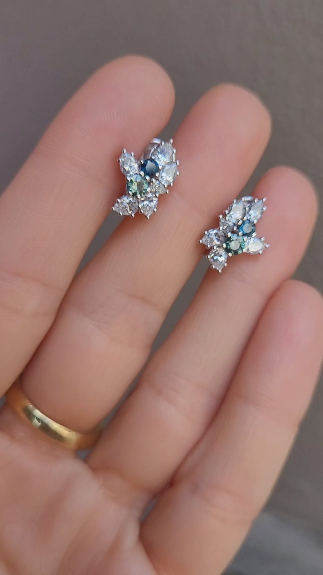 video of Australian Teal Sapphire & Moissanite Cluster Earrings held between fingers
