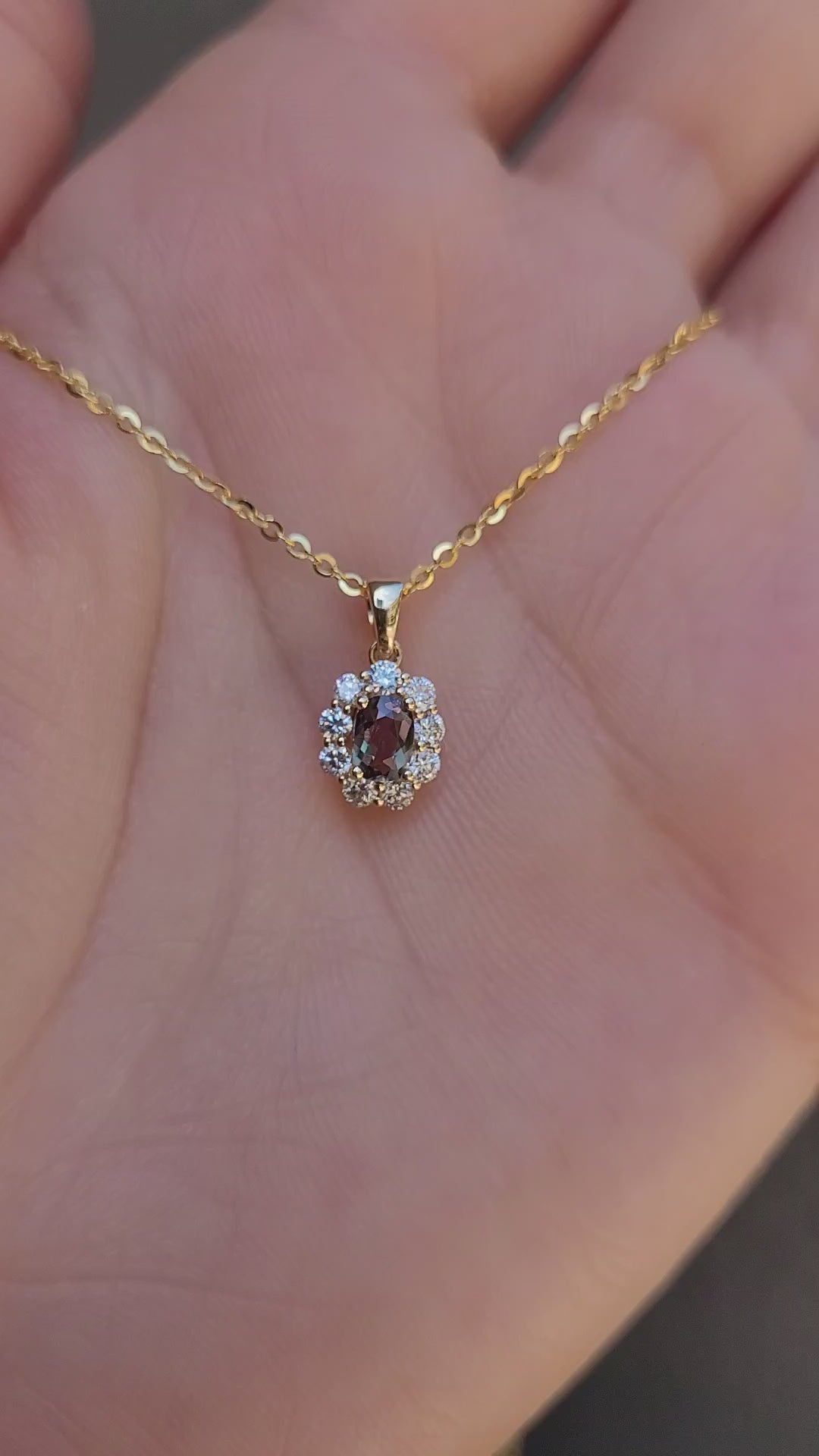 video of Natural Alexandrite Halo Pendant 0.34ct Oval Cut in 18K Yellow Gold in neutral background held in a hand