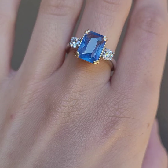 video of Hand wearing a ring with a 4.6ct blue sapphire on a neutral background
