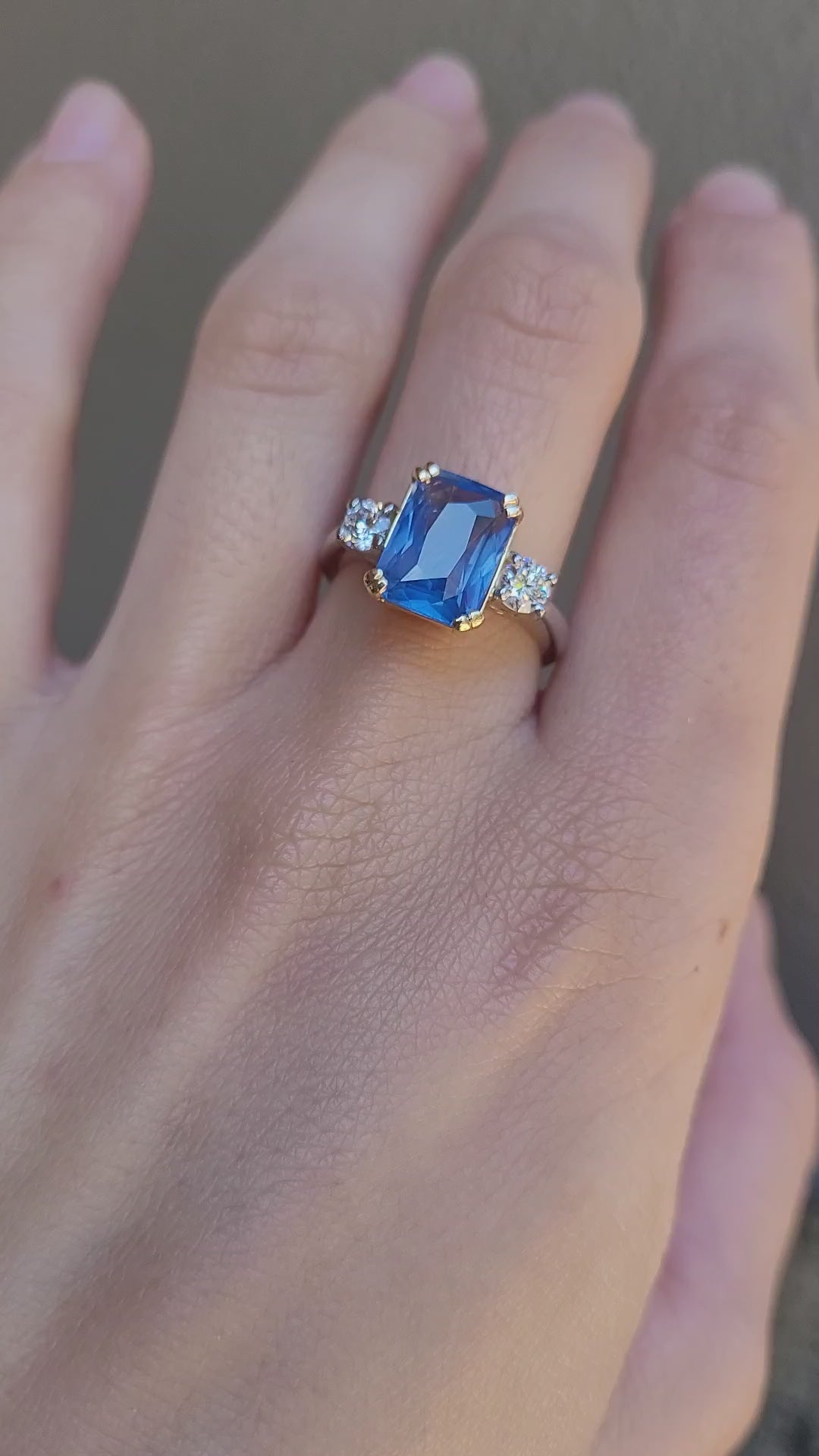 video of Hand wearing a ring with a 4.6ct blue sapphire on a neutral background