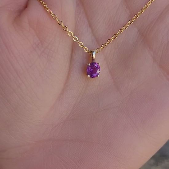 video of a Natural Unheated Pink Sapphire Pendant in 18K Yellow Gold held in a hand