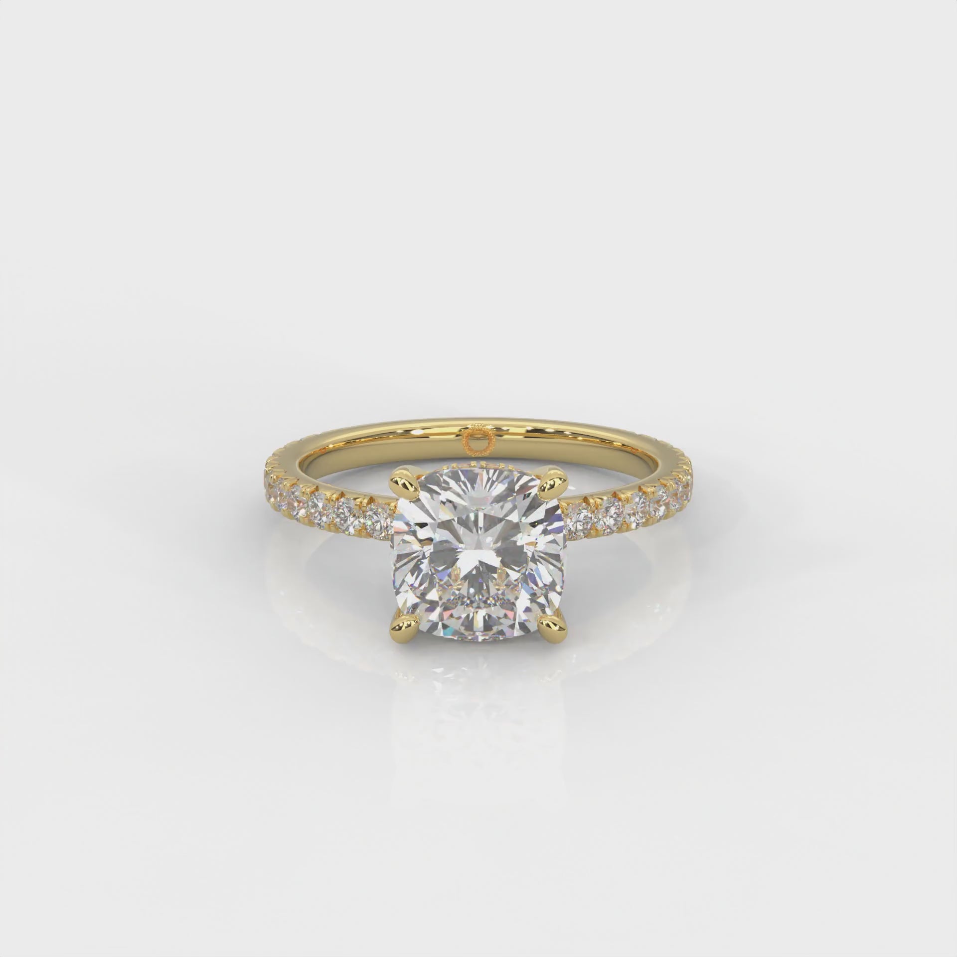video of yellow gold ring with a cushion cut diamond and smaller diamonds on the band against a white background