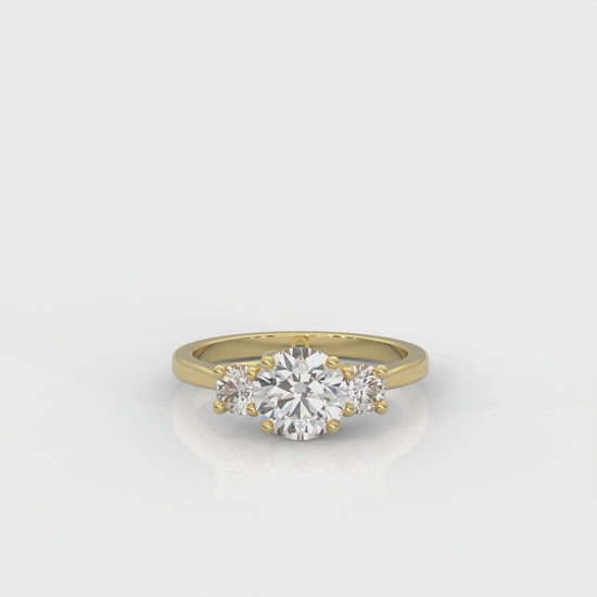 video of yellow gold three stone ring with round side diamonds and round centre stone on white background