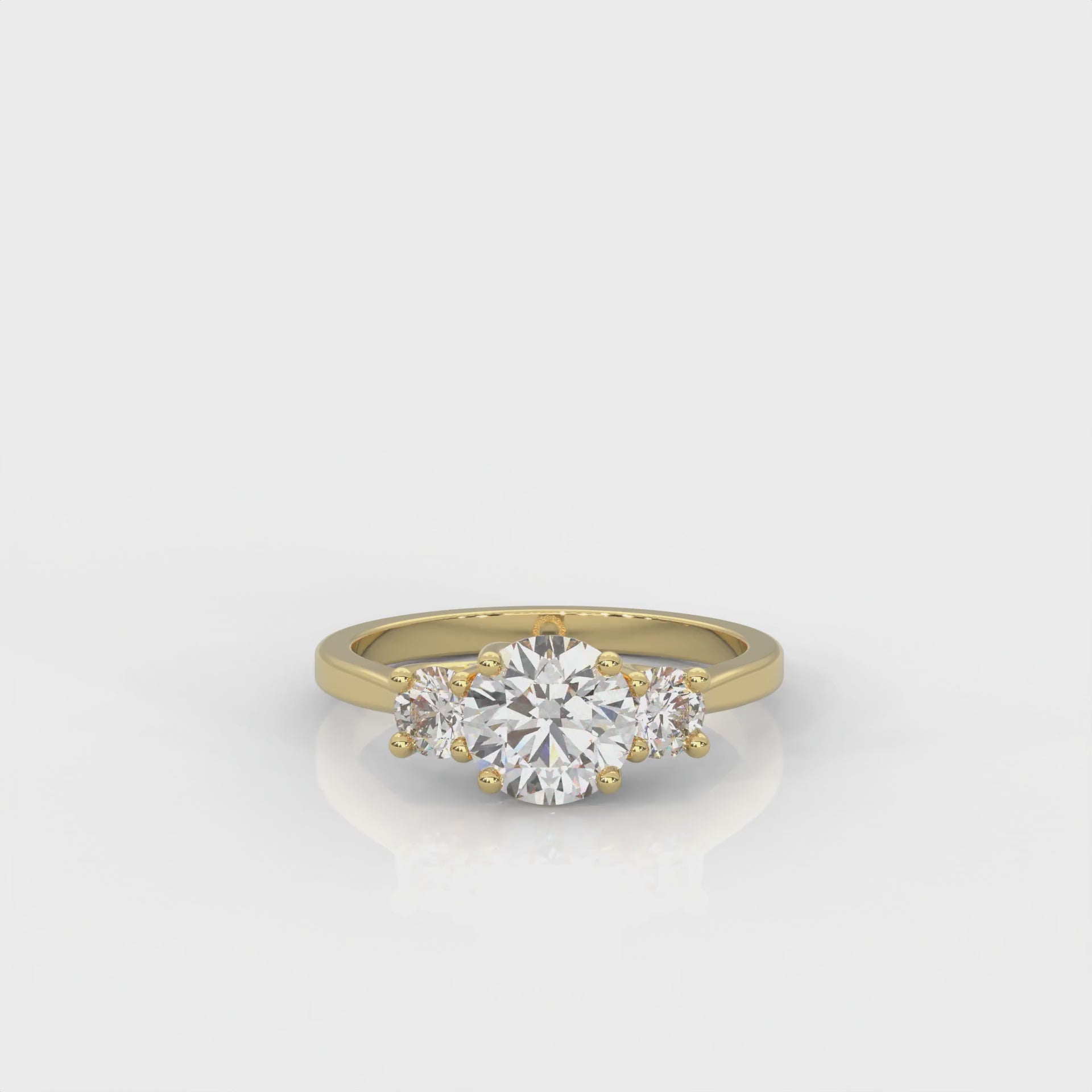 video of yellow gold three stone ring with round side diamonds and round centre stone on white background