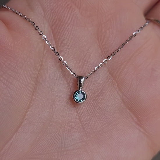 video of Australian teal sapphire platinum pendant in gray background
