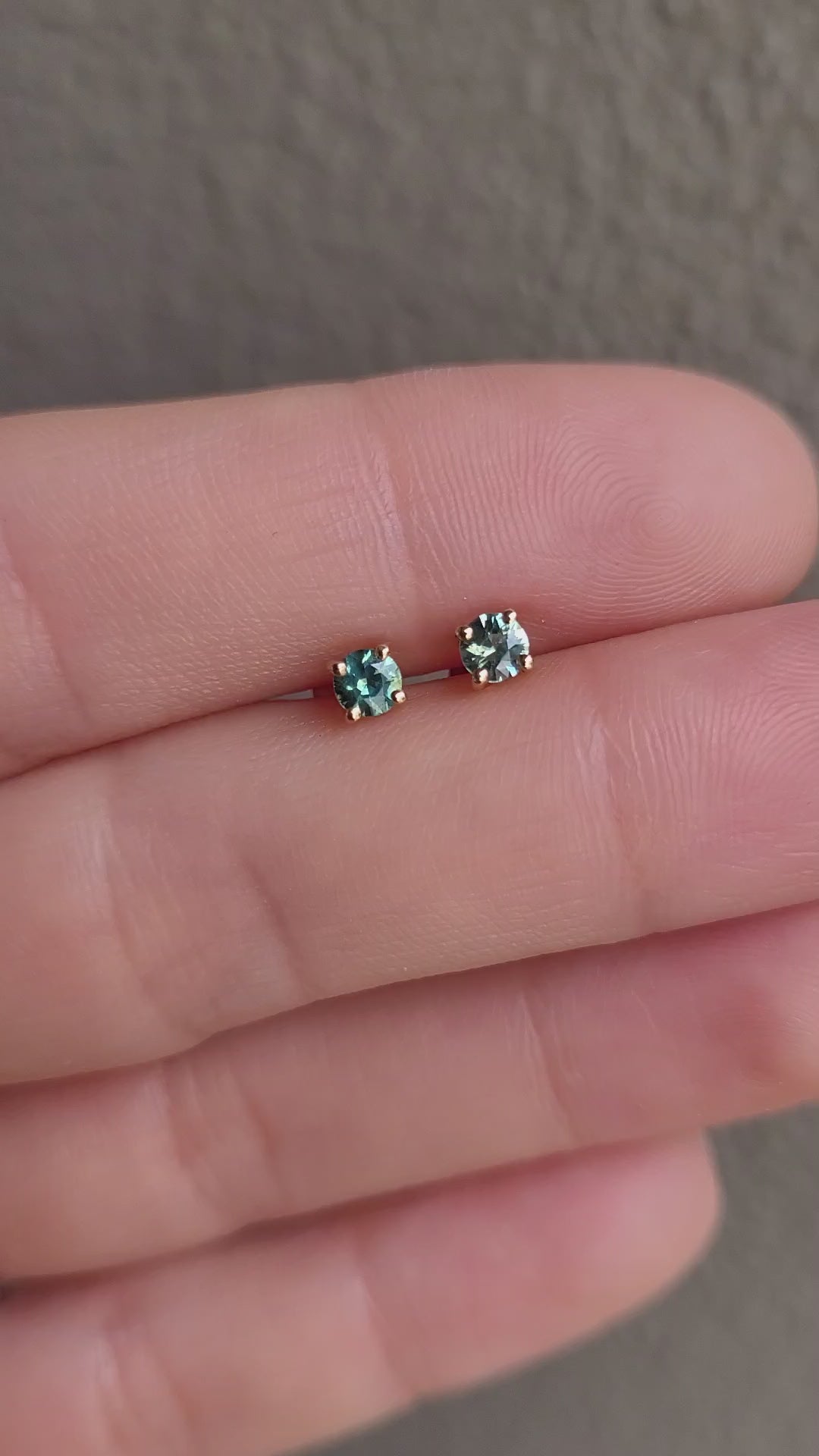 video teal sapphire earrings in gold in gray background