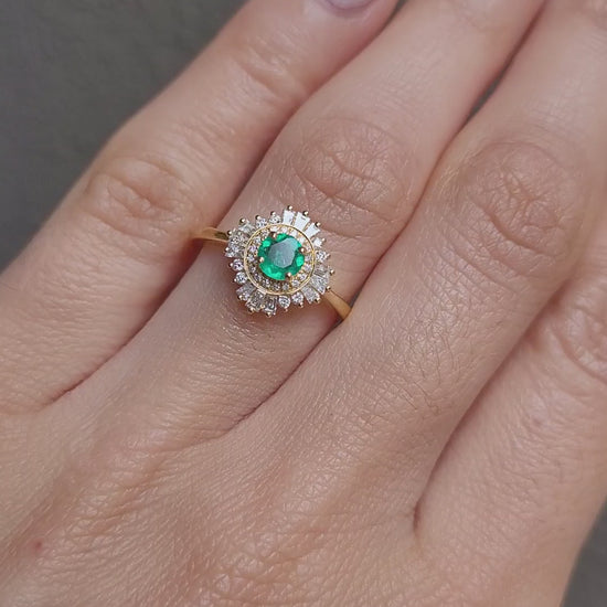 video of emerald Art Deco ring with diamond halo in light gray background