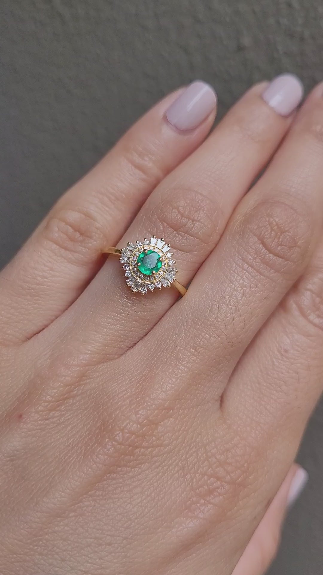 video of emerald Art Deco ring with diamond halo in light gray background