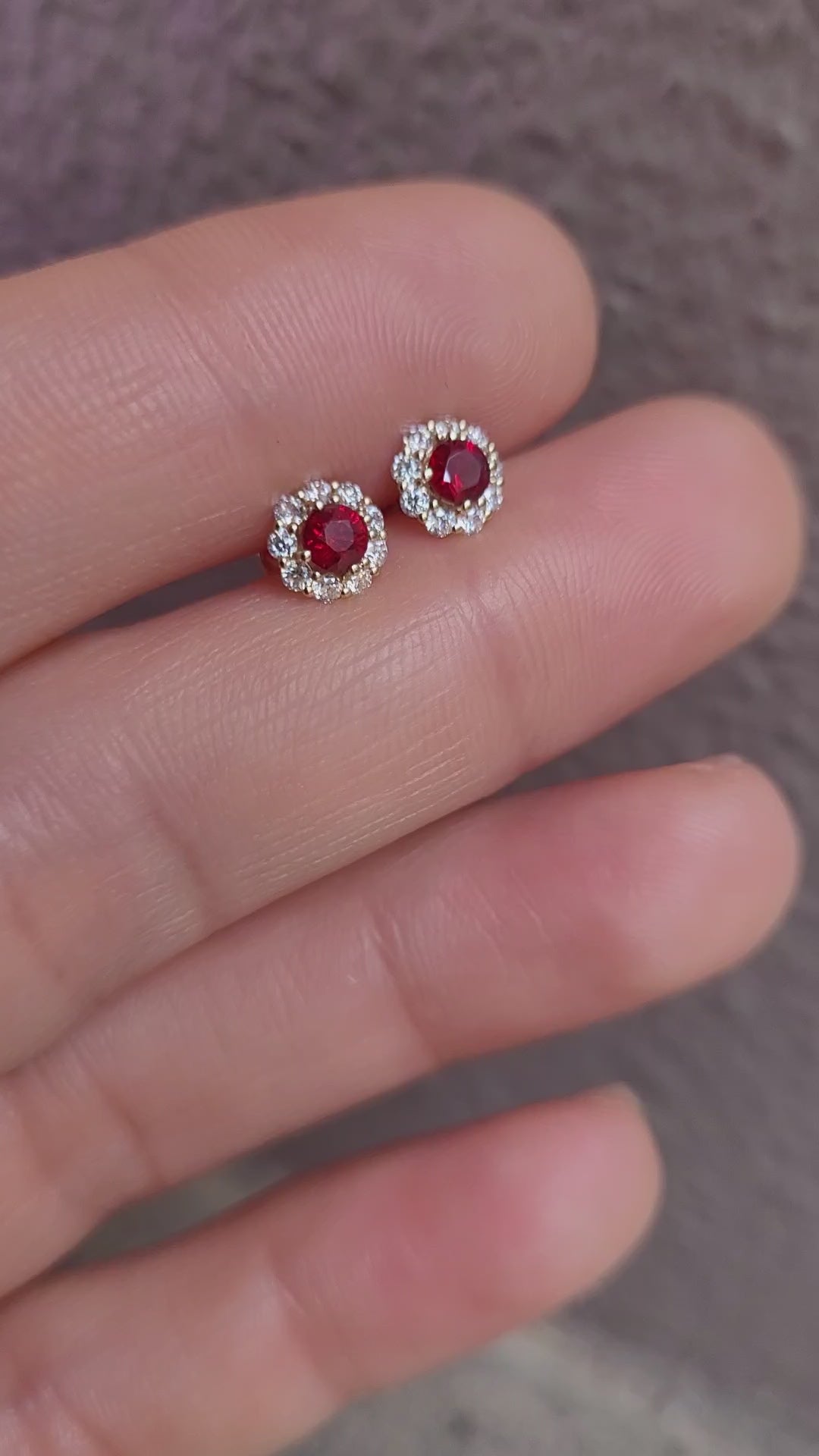 video of ruby studs held on a hand