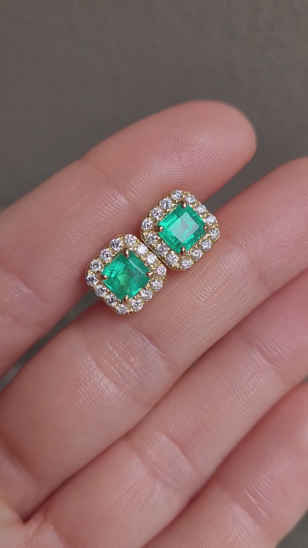 video of hand holding Colombian Emerald 1.91ct & Diamond Halo Stud Earrings