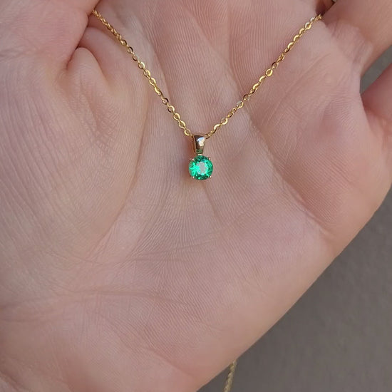video of Colombian emerald gold pendant in gray background