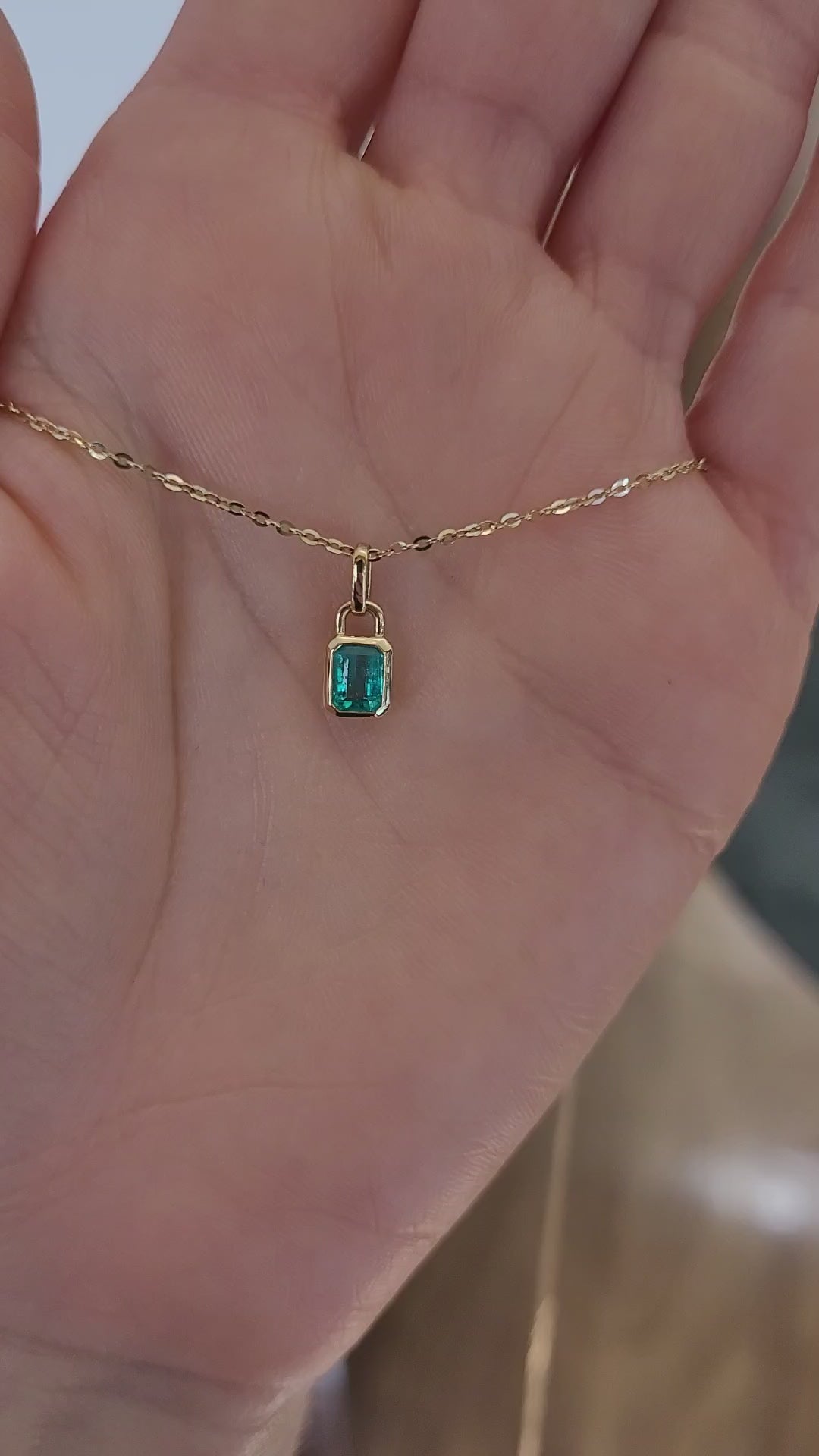 video of 0.41ct Colombian Emerald Pendant on a hand