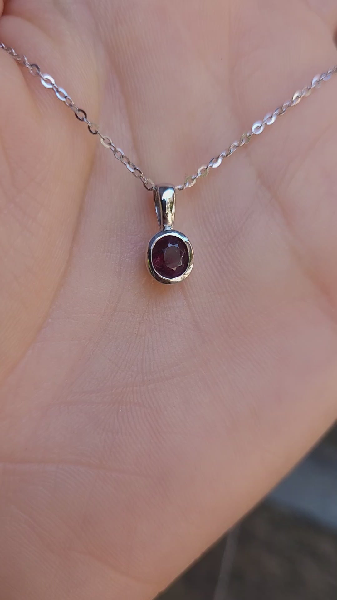 video of Platinum pendant with natural ruby shown on a hand