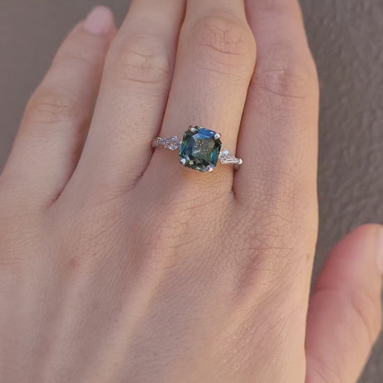video of a hand wearing a Natural Teal Sapphire & Kite Diamond Ring in Platinum on a neutral background