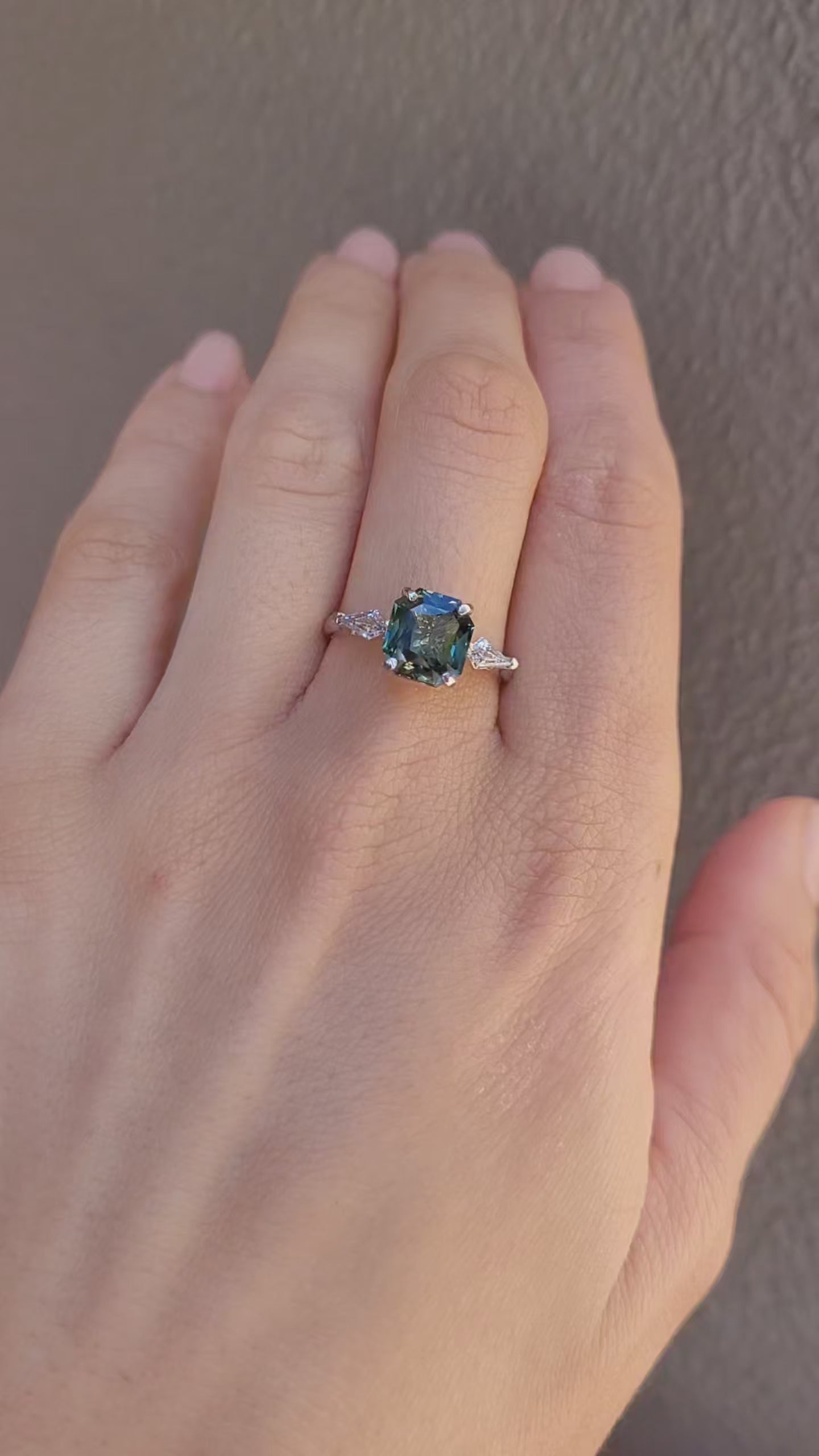 video of a hand wearing a Natural Teal Sapphire & Kite Diamond Ring in Platinum on a neutral background
