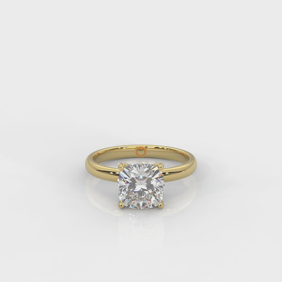 front view of Yellow gold solitaire ring with cushion cut diamond on a white background