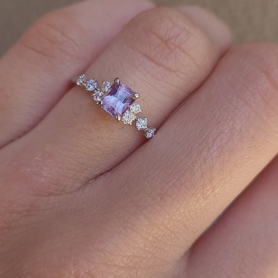 video on hand of Platinum pink sapphire ring with natural diamonds in gray background