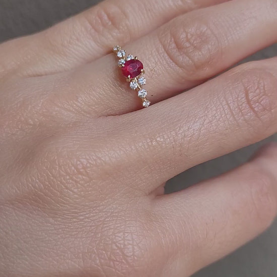 video of hand wearing ruby and diamonds gold ring in yellow gold in neutral background